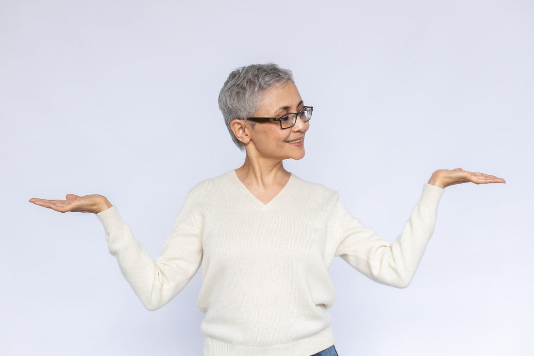 Woman smiling and holding up both hands as she weighs her options. 