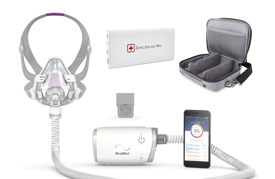ResMed AirMini CPAP device with mask, power adapter, carrying case, and smartphone app on a white background